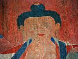 Lo Manthang Thubchen 03-2 Entrance Left Wall Painting Of Buddha Close Up The Nova Lost Treasures Of Tibet DVD had already told me about the restoration of the abandoned Thubchen gompa and its paintings. British architect John Sanday led the restoration of the Gompa roof in the traditional way with wood, flat stones and mud. Art conservator Rodolfo Lujan from Rome led the restoration of the paintings using the same techniques as the Sistine Chapel. Buddha�s face glows with the restored red, green and blue colours on the left wall before the assembly hall entrance door at Thubchen Gompa in Lo Manthang.